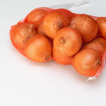 Onions,In,The,Red,Net,On,The,White,Table